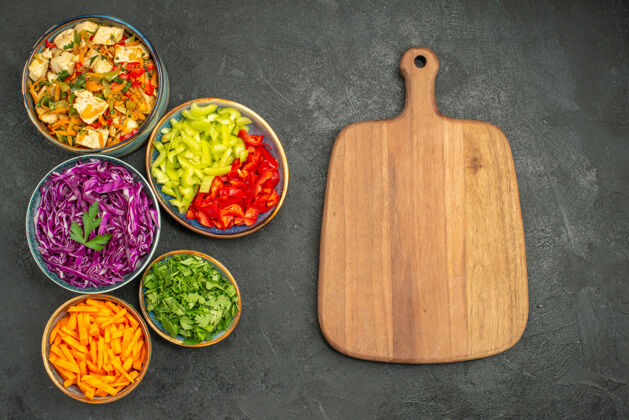 水果顶视图不同的蔬菜切片与鸡肉沙拉在黑暗的桌子上健康沙拉饮食胡椒蔬菜沙拉