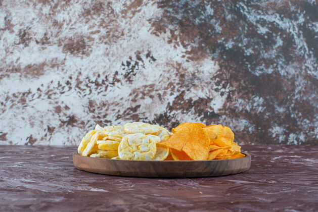 风味奶酪片和薯片放在大理石表面的盘子里一份美味美味