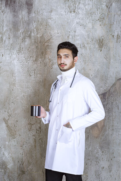 健康男医生拿着听诊器端着一杯咖啡药医生男人