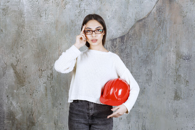 工程师戴着红色头盔的女工程师 看上去很体贴 或者有个好主意安全梦想人