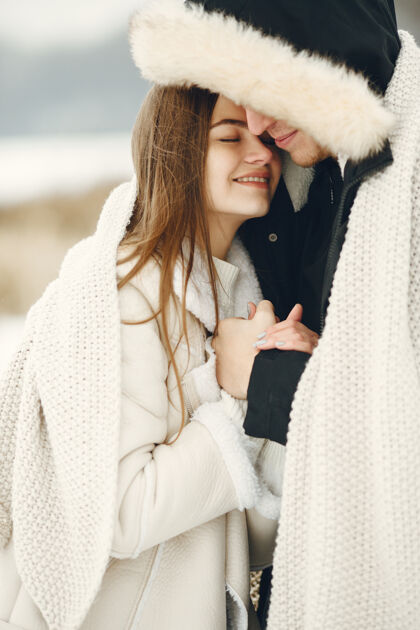 雪一对夫妇在雪林中散步的生活方式照片人们在户外度过寒假情侣白色女孩