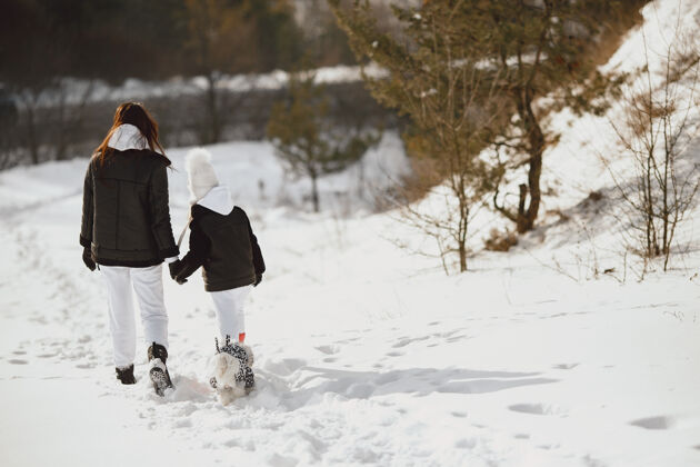 帽子一家人在一起过圣诞节女人和小女孩在森林里人们在散步雪运动户外