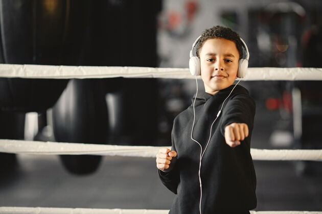 健身年轻勤奋的拳击手学习拳击运动中心的孩子戴着耳机的孩子活跃健身房儿童