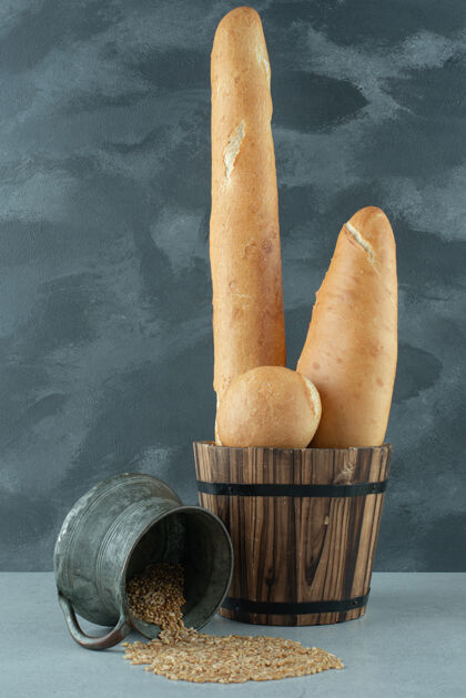 新鲜把面包放在桶里 在石头表面放一大杯大麦美味食品有机