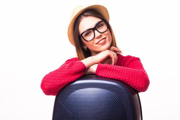 时尚带着旅行箱站着的年轻休闲女士-隔离在白墙上职业概念行李太阳镜休闲