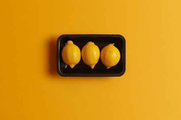 顶部容器中新鲜成熟柠檬的俯视图可以与其他食物一起装饰 以提供酸味制作柠檬水的关键成分含有维生素 矿物质和精油的柑橘类水果饮食风味柑橘