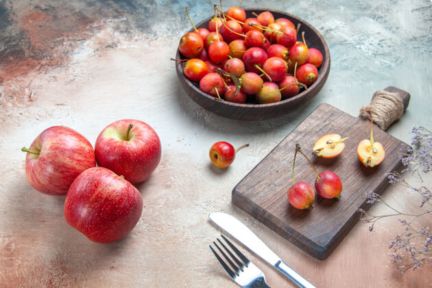 营养侧面特写查看樱桃叉子刀子樱桃在碗里和板上三个苹果樱桃三饮食