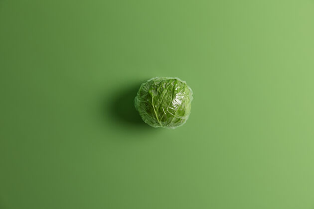 烹饪头顶拍摄的绿色卷心菜包裹在透明的塑料食品膜中 随时可供食用从花园或田间采集健康的有机产品丰收 园艺和农业理念顶部蔬菜视图