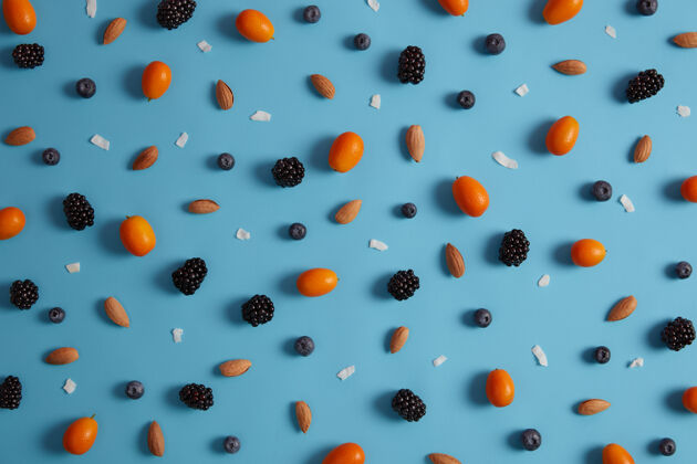 背景新鲜营养的金橘 蓝莓 黑莓和杏仁俯视图 背景为蓝色工作室夏季浆果系列和热带柑橘类水果有机营养和收获理念黑莓蓝莓细节