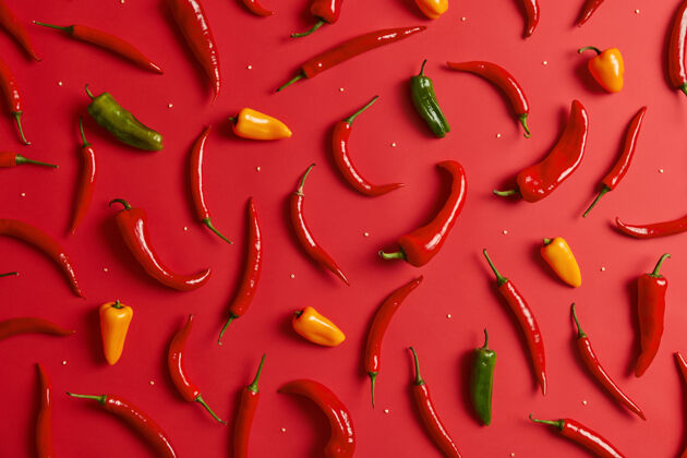 热在红色背景上分离的五颜六色的辛辣辣椒用于制作浓咖喱的热绿黄色和红色辣椒花园里种植的草药营养和食物概念创意成分扁平品种香料