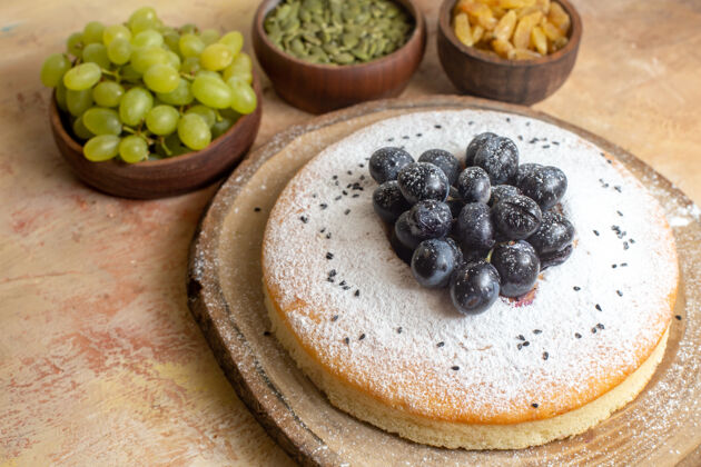 食物侧面特写一个蛋糕一个蛋糕在板上葡萄干绿色葡萄南瓜子蓝莓水果早餐