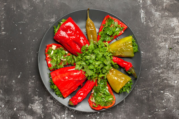 食物顶部特写镜头五颜六色的胡椒不同种类的胡椒与草药的黑色盘子西红柿晚餐午餐