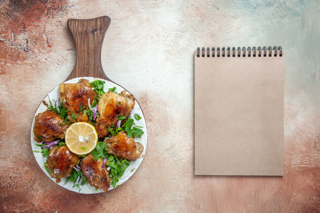 食物顶部特写查看鸡肉一个开胃的鸡肉与柠檬香草对板奶油笔记本上的拉瓦什奶油洗漱一餐