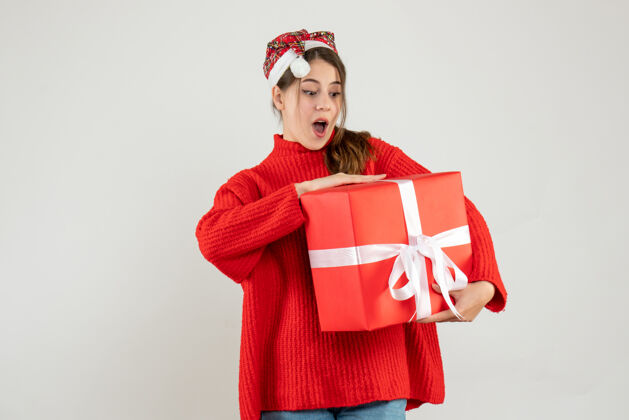 圣诞老人前视图兴奋的女孩戴着圣诞帽拿着礼物兴奋的女孩节日购物者