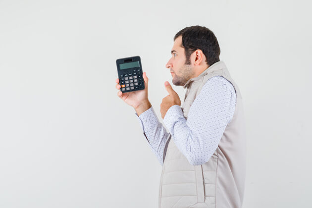姿势一个年轻人一手拿着计算器 穿着米色夹克和帽子竖起大拇指 神情沉思前视图模型自然显示