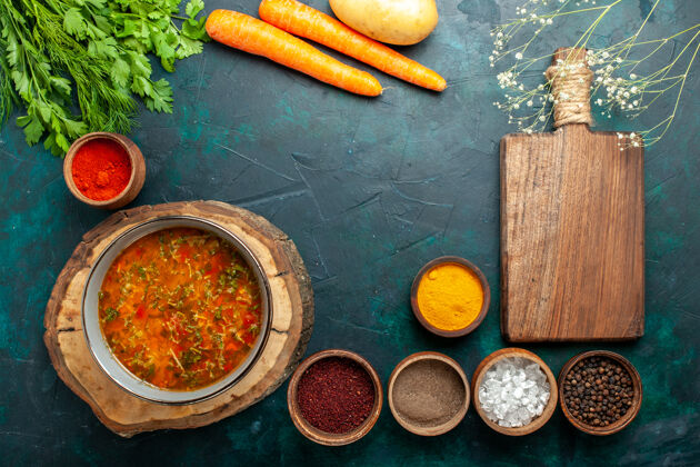 生的顶视图蔬菜汤与调味品在深绿色桌配料汤餐食品蔬菜桌子胡萝卜蔬菜