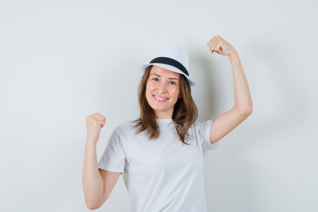 帽子一个年轻女孩戴着白色t恤帽子展示着赢家的姿态 看上去很幸运童年幸运小