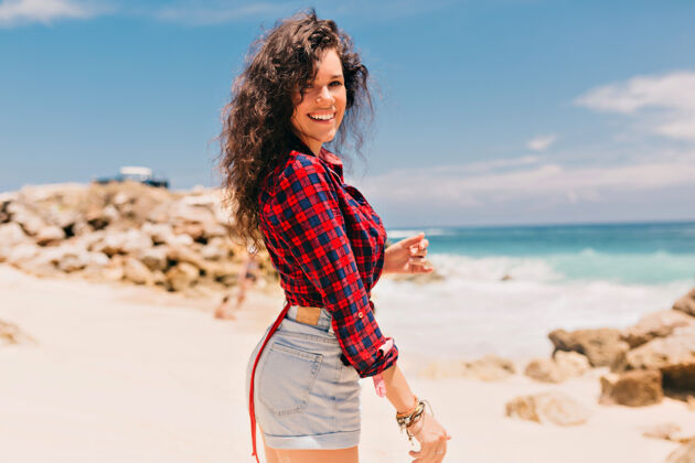 海洋兴奋快乐的女孩穿着短裤和衬衫在沙滩上的海边女人人太阳