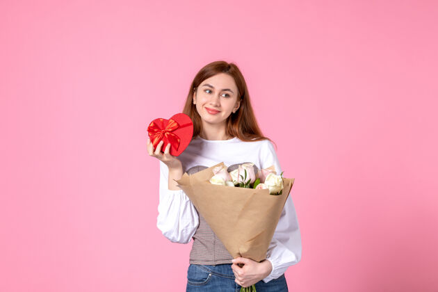 人正面图：年轻女性 带鲜花 作为女性节礼物 粉色背景 水平三月平等 性感女性约会 玫瑰爱情花束年轻女性礼物