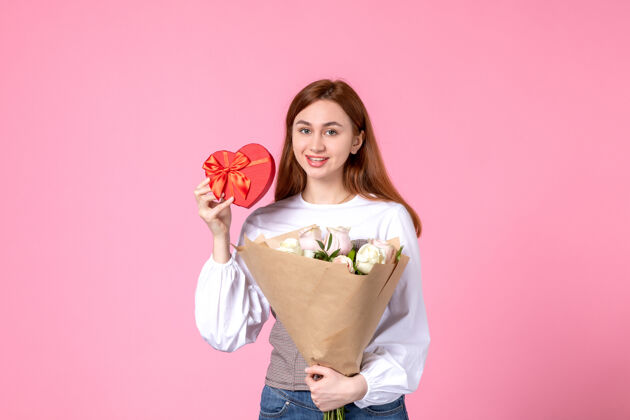 年轻女性正面图：年轻女性 带鲜花 作为女性节礼物 粉色背景 水平三月 女性平等 玫瑰 爱情 性感 女性约会人花玫瑰