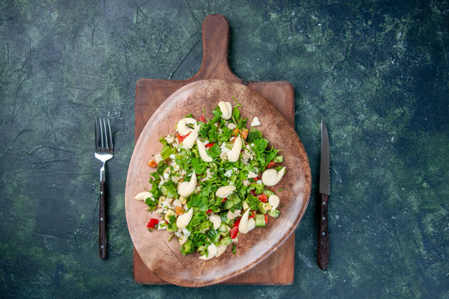 里面顶视图美味的蔬菜沙拉在盘子里用刀叉在深蓝色的背景上烹饪健康的颜色适合餐厅晚餐厨房午餐晚餐烹饪厨房