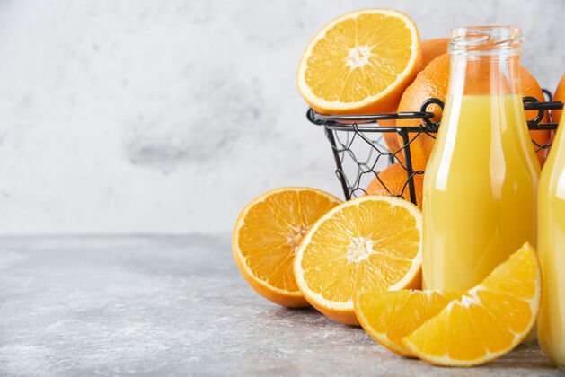橙子石桌上放着一杯果汁和新鲜的橙子热带味道橙子