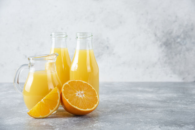 水果石桌上放着一杯果汁和新鲜的橙子美味圆形果汁