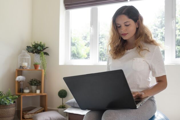 远程工作中等身材的女人用笔记本电脑工作女人生活方式房子