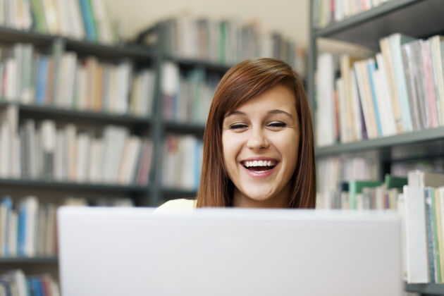 大学快乐的学生在图书馆使用笔记本电脑Campus笔记本电脑欢呼