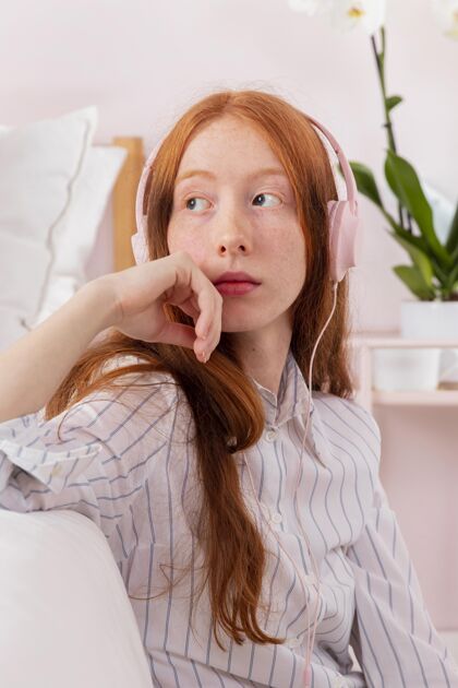 模特戴着耳机在家工作的女人年轻人工作室内