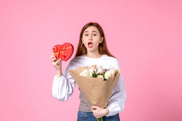 花束正面图：年轻女性 带鲜花 作为女性节礼物 粉色背景 水平三月 女性约会 平等玫瑰 性感女性礼物花玫瑰