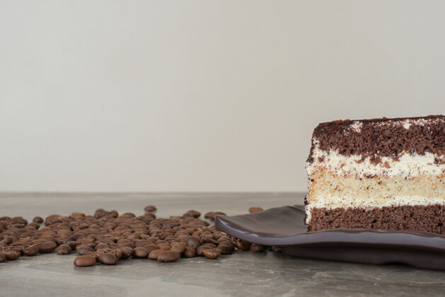 蛋糕在大理石桌上放一片巧克力蛋糕和咖啡豆巧克力切片面包房