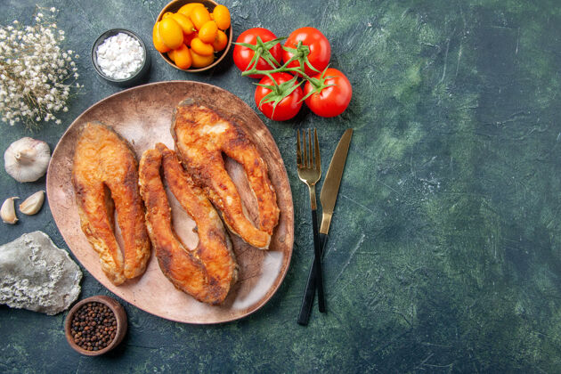炸鱼上图：美味的油炸鱼放在棕色盘子里 餐具放在五颜六色的餐桌上 还有免费的空间香料南瓜套餐