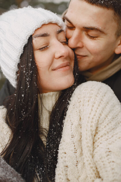 季节一对情侣在雪林中散步的生活方式照片寒冷温暖舒适