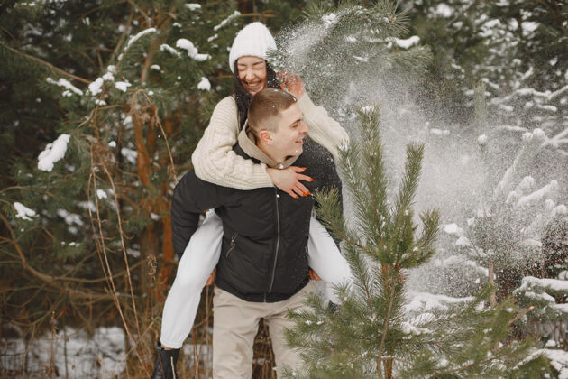 毛衣一对情侣在雪林中散步的生活方式照片男性约会温柔