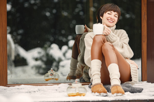 手穿着白毛衣 喝茶的女人的特写肖像快乐季节冷冻