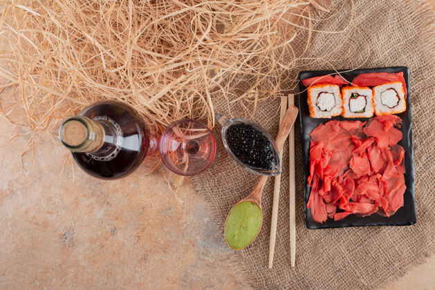 酒庄一瓶葡萄酒 酒杯和寿司放在粗麻布上深色桌子粗麻布