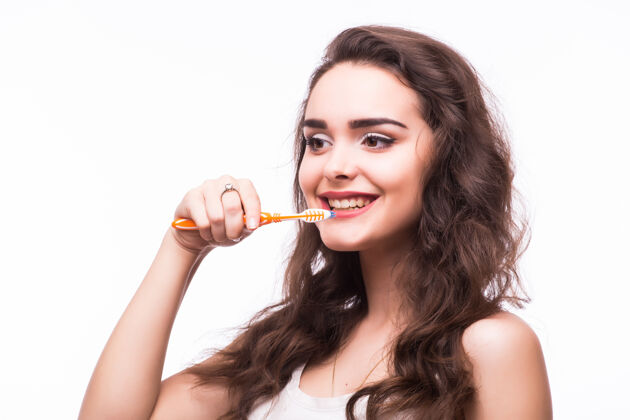 年轻人年轻的女人拿着牙刷 孤零零地站在白色的背景上刷子女性牙科