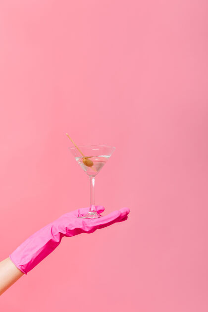 电话粉红色墙上手拿橄榄的马提尼杯的照片马提尼酒成人可爱