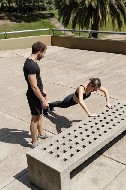 女人大角度的男人和女人在户外做俯卧撑运动健身男人