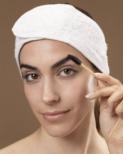 女人年轻的女人在照顾她的眉毛女人眉毛治疗治疗