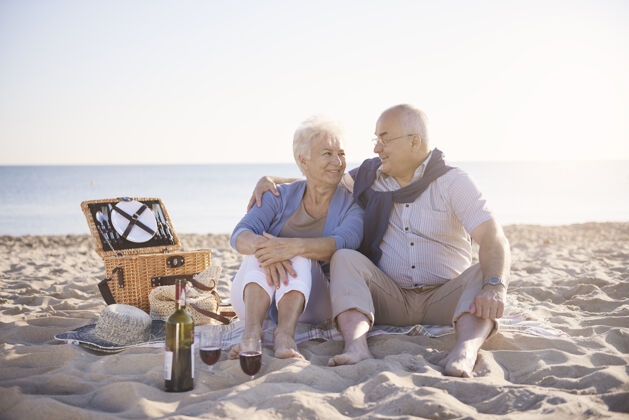 约会美好的一天在沙滩上度过老年夫妇在沙滩上 退休和暑假的概念丈夫假日休息
