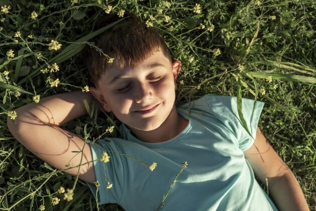 户外中枪笑脸小子躺在草地上生活方式童年年轻