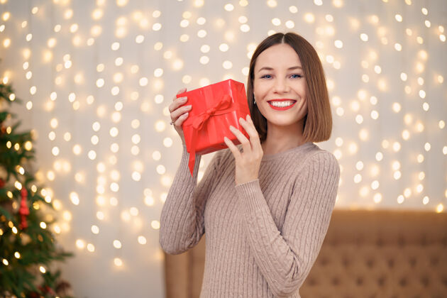 礼物年轻快乐女子红唇画像看着包装好的礼盒灯光新鲜美女