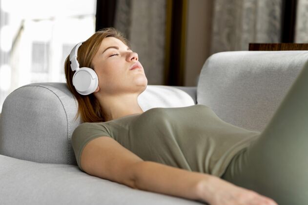 娱乐沙发上戴着耳机的中枪女人冥想生活方式益处