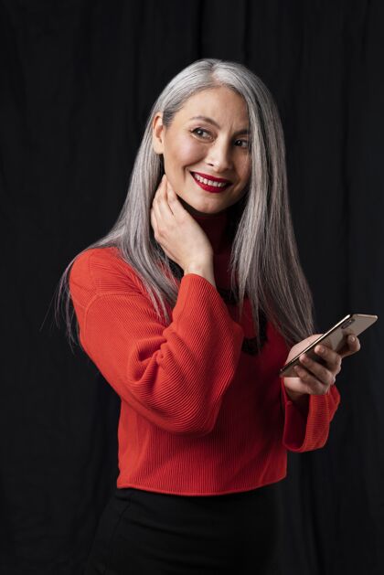 技术美丽的高级女性肖像使用手机美女笑脸女性