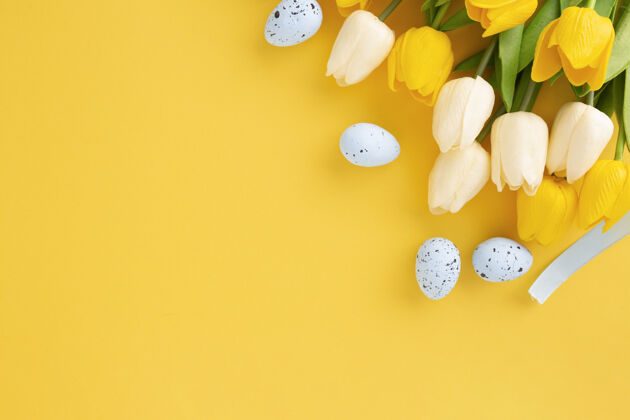 复活节问候用郁金香和逾越节彩蛋做成的复活节彩画 背景为黄色 有复制空间花平层庆祝