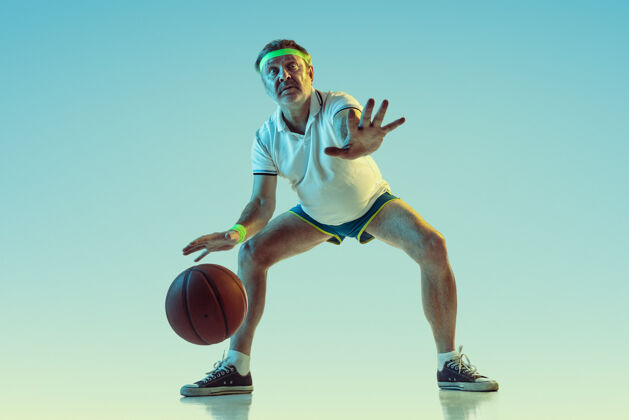 比赛高级男子在霓虹灯下的斜坡墙上打篮球身材魁梧的白种人男模保持活跃 运动运动 活动 运动 幸福 健康的生活方式的概念球动作运动服