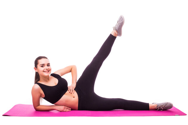 健身摄影棚拍摄的一个年轻的健康女子正在做瑜伽练习隔离在白色背景运动女孩锻炼