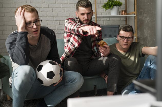 最好的朋友男性朋友在电视上观看披萨和足球运动的前视图啤酒朋友男人